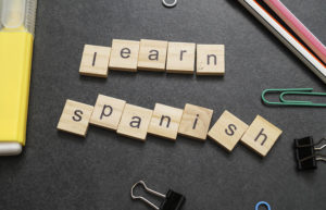 Word LEARN SPANISH written on wood block. Close up